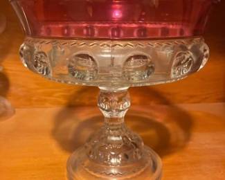 Vintage Ruby Flash "Kings Crown" Pedestal Glass Dish / Compote: A classic Early American Pattern Glass (EAPG) style footed compote / pedestal dish in the iconic "Kings Crown" (also known as Thumbprint) pattern. Features a deep ruby red stained/flashed upper rim with clear pressed glass "thumbprint" indentations along the main body, a sculpted pedestal stem, and a patterned dome base.