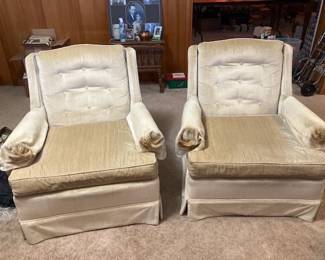 A matching pair of vintage Clyde Pearson high-back club armchairs featuring tufted backrests, rolled padded arms, and pleated skirt bases upholstered in light cream/gold crushed velvet.