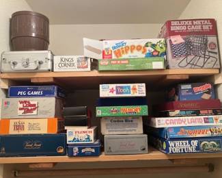 Board Games & Family Activity Collection: A large, diverse shelf collection of classic family board games, vintage trivia games, card games, party games, and novelties.
