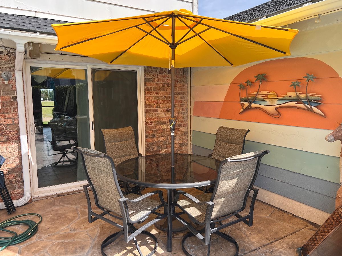 This 5-piece patio set includes four swivel chairs and a table with a central umbrella hole.