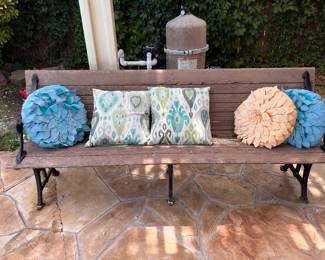Classic wooden slat Garden Bench with ornate cast-iron legs and armrests.