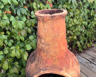 Traditional Mexican-style clay chiminea crafted from terracotta clay material, featuring a rustic handcrafted appearance with metal stand.