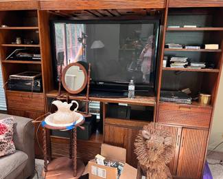 Large vintage wooden entertainment center wall unit with a warm brown finish. Features a spacious center TV cavity, two flanking side shelving units for books or media, upper storage shelves, and lower cabinets with slatted wooden doors. This is modular and can be disassembled into three separate units.