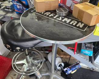 In addition to the table, there is a set of craftsman glasses, coasters, and motorcycle stools.