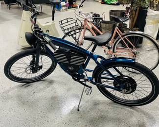 SHELBY ELECTRIC BICYCLE. THIS IS A LICENSED COLLABORATION WITH CAROLL SHELBY, FEATURING THE ICONIC SHELBY BLUE PAINT WITH BLACK RACING STRIPES AND A CUSTOM BATTERY HOUSING DESIGNED TO MIMIC A V8 ENGINE BLOCK.  FIRST EDITION LEGACY MODEL 081 ONLY 300 UNITS - LIMITED 