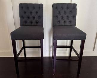 Set of 2 Upholstered Counter Height Bar Stools  Stylish and comfortable set of two counter-height bar stools with tufted charcoal gray upholstery and dark espresso wood legs. These chairs are a great fit for a kitchen island, breakfast bar, or game room.  Features:  * Set of 2 * Counter-height stools * Charcoal gray tufted upholstered seats * Dark espresso wood legs * Built-in footrests for added comfort * Sturdy construction * Good condition with normal wear from everyday use  Selling as part of an estate sale.  Dimensions: Available upon request.  $95 OBO