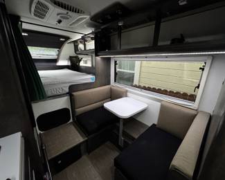 nucamp truck camper dining room converts to twin mattress, storage is above and can also convert to second bed and sleeps a queen mattress with tons of extra room for storage 