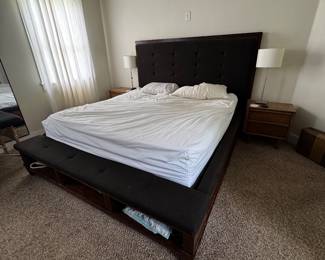 King Storage Platform Bed Frame  Modern king-size platform bed with a dark wood frame and upholstered black tufted headboard. Features built-in upholstered bench seating at the foot of the bed plus open storage cubbies underneath, making it perfect for extra blankets, pillows, books, or baskets.  Features:  * King size * Solid dark wood frame * Upholstered tufted headboard * Built-in padded bench at the foot of the bed * Open storage compartments for added organization * Sturdy platform design (no box spring required) * Normal wear from use, overall in good condition  $690 OBO - does not include mattress or bedding