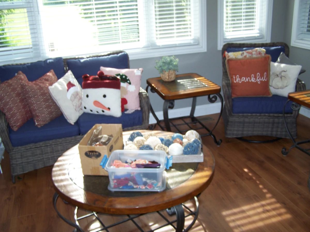 RATTAN SETTEE & SWIVEL CHAIR, DECORATOR PILLOWS, COFFEE TABLE & LAMP TABLE