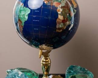 This vintage-style tabletop world globe is meticulously crafted with deep blue lapis lazuli oceans and multi-colored semi-precious gemstone inlays representing the individual continents and countries