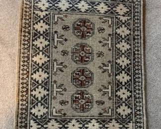 Dimensions: 1’ 8” x 2’ 7” Description: Handmade Iranian or Turkish accent rug. Material: 100% wool Design: Traditional geometric tribal motif Color: Beige with deep red color pallet referred to as Bokhara or Anatolian/Afghan medallion rug Price: $150