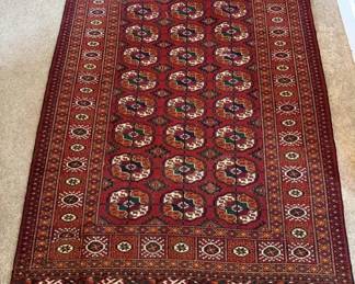 Dimensions: 3’5” x 6’0” Description: Hand knotted Bokhara rug.  Color: Features a signature red background, with repeating geometric gol pattern. (Medalion motif color pallet: rich warm red complimented by black, white/nave accent, high quality wool) Price: $400