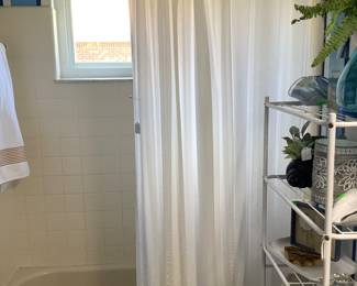 Cabinet with items and shower curtain.