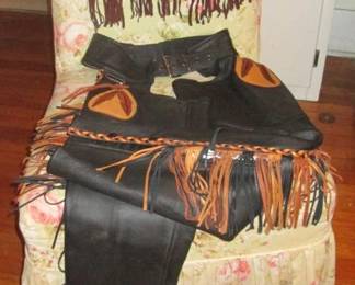 Born to be wild in this pair of full hide deerskin fringed chaps. Check out the feather applique on both legs. And to go with it, a genuine vintage Flower Power fringed vest in suede with brass rivets.  Both items UNWORN! As new condition! 