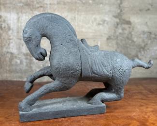 This lot features a 1961 Austin Productions Tang Dynasty style horse sculpture made of cast durastone that measures, 13” H x 18” W x 6” D.