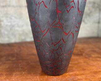 This lot features a stunning Italian glass vase with a lava effect by Dolbi Cashier. This vase measures, 20” H. Dolbi Cashier Italian glass vases, produced around 1993, are highly collectible pieces of art glass. They typically feature vibrant two-tone color palettes, like seeded aqua glass bodies with ruby red bases, and are known for their controlled bubble (bullicante) technique and statement silhouettes.