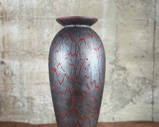 This lot features a stunning Italian glass vase with a lava effect by Dolbi Cashier. This vase measures, 20” H. Dolbi Cashier Italian glass vases, produced around 1993, are highly collectible pieces of art glass. They typically feature vibrant two-tone color palettes, like seeded aqua glass bodies with ruby red bases, and are known for their controlled bubble (bullicante) technique and statement silhouettes.
