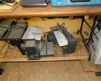 Starting on the left, we have a router table, a table top belt sander, and rounding out the trio, a small scroll saw for the most delicate of woodworking projects