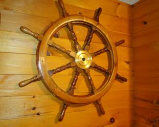 Ships wheel on the wall.  Some ship is missing a wheel