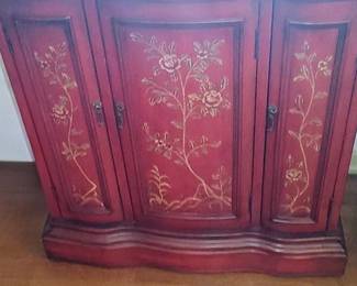 red Chinoiserie accent cabinet features hand-painted gold floral motifs and curved paneled doors.
