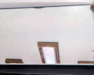 vintage mirrored vanity tray features clear Lucite side handles and decorative brass-toned floral corner feet