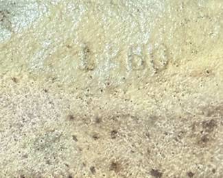 shows an in-mold number 1260 stamped or cast directly into the back or base of a vintage cast-iron piece. In antique cast-iron manufacturing—this one is made by L Judd company