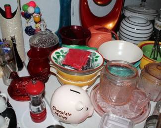 Pyrex yellow and green-patterned bowls, Fiesta pitcher, and striped ceramic canister set / Pink depression glass jar, candy dish with lid, and small glass pitcher