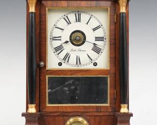 A late 19th century Seth Thomas Mini Column & Cornice shelf clock.  8-day spring driven time, strike and alarm movement with painted metal dial and Roman numerals.  Rosewood case with a molded cornice over single door, clear dial glass and mirrored lower flanked by turned Ebonized columns over a pendulum window with molded Brass bezel on a stepped molded base.  Interior paper label 80% intact.  Refinished with slight wear, re-painted dial, running when cataloged.  15 3/4" high.  ESTIMATE $100-150