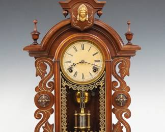 A 19th century Kroeber Victorian shelf clock.  8-day time and strike E. N. Welch movement with papered metal dial and Roman numerals.  Walnut case with carved and gilded detail features an arched top with Liberty Mask turned finials above an arched door with stenciled glass flanked by reticulated pilasters on a molded base.  Refinished with slight wear, some dial wear, running when cataloged.  25 1/4" high.  ESTIMATE $100-150