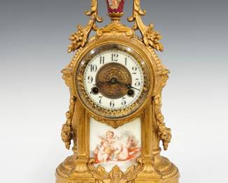 A turn of the century Waterbury Satoris model mantel clock. 8-day spring driven time and strike movement with flat porcelain dial and Arabic numerals with embossed Brass center. Louis XV Style cast spelter case foliate detail and inset porcelain panel on a scrolled base. Restored Gold finish with slight wear, replaced pendulum, running when cataloged. 13 1/2" high overall. ESTIMATE $100-150