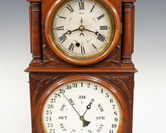 A late 19th century Ingraham Calendar shelf clock.  8-day time and strike movement and lower "B B Lewis" calendar mechanism indicating date and month, papered metal dials with Roman/Arabic numerals and apertures indicating day and month.  Walnut case with shaped crest and carved detail, circular upper door flanked by turned columns over a square lower door with carved detail on a molded plinth base.  Refinished with minor wear, some dial wear, running when cataloged.  21 3/4" high.  ESTIMATE $300-400