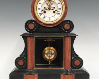 A 19th century French mantel clock by Samuel Marti, Paris.  8-day time and strike movement with visible escapement and two piece White porcelain dial with Roman numerals, fancy gilded pendulum with porcelain insert, serial #2073.  Black marble Empire style case with Rouge marble detail features a rounded top with scrolled brackets over a body with central beveled glass flanked by reeded pilasters and scrolled bracketson a shaped plinth base.  Minor wear, some tiny edge flakes, crack in rear door frame, running when cataloged.  16 3/4" high.  ESTIMATE $400-600