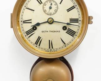 A late 19th century Seth Thomas Ships Bell model wall clock.  1-day time and strike movement with lever escapement and Ships Bell strike, Silvered dial with Roman numerals and subsidiary seconds.  Brass housing and bell mount on the wood backboard.  Some wear, running when cataloged.  11 1/2" high includes the mounting flanges.  ESTIMATE $200-300