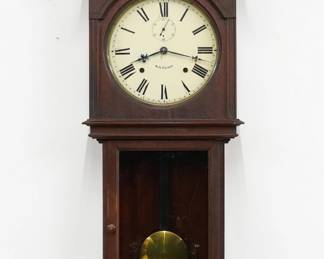 A turn of the century Seth Thomas Umbria model wall clock.  8-day spring driven time and strike movement with painted metal dial and Roman numerials, subsidiary seconds.  Mahogany case with a pediment top and turned finial, dial door with circular glass and reeded frame oner a lower door with simple molded frame, shaped apron and lower drop.  Original dark finish with crazing, minor dial wear, running when cataloged.  42" high.  ESTIMATE $300-500