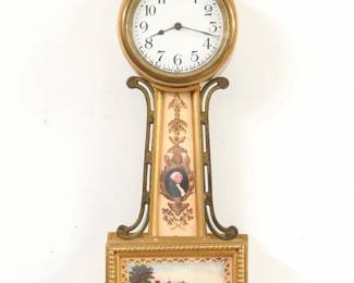 A 1930's miniature New Haven Banjo clock, Washington/Mt Vernon model.  8-day time only wind movement with lever escapement and porcelain dial with Arabic numerals, subsidiary seconds.  Gilded wood case with Brass Eagle finial and side arms, reverse painted throat glass and lower glass.  Original finish with some wear, running when cataloged.  17 3/4" high.  ESTIMATE $100-150