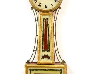 A 19th century American Presentation Banjo clock.  8-day Brass, weight driven time only movement with painted Iron dial and Roman numerals marked "Warranted..".  Gilded Mahogany case with pierced Brass arms, Brass dial door with convex glass over reverse painted throat and lower door glasses, shaped drop with fluted detail.  Re-Gilded with minor wear, restored painted glasses, crack in throat glass, replaced finial, running when cataloged. 40 1/2" high overall. ESTIMATE $2,000-3,000