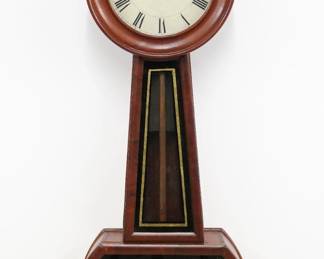 A mid 19th century Banjo clock attributed to George D. Hatch, North Attleboro, MA.  8-day weight driven time only movement with painted metal dial and Roman numerals, wooden pendulum stick with Brass bob.  Cherry case with circular dial door over a tapered throat and square lower door, both having glasses reverse painted with gilded detail.  Refinished with minor wear, some dial wear, running when cataloged.  29 1/2" high.  ESTIMATE $400-600