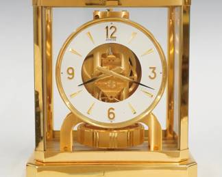 A late 20th century Atmos perpetual mantel clock by LeCoultre et Cie.  Caliber 528.8, 15j movement with circular White enameled dial and Arabic numerals, powered by changes in atmospheric pressure.  Brass case with glass panels at top, front, back and sides.  Slight wear, running when cataloged.  9 1/4" high.  ESTIMATE $400-600