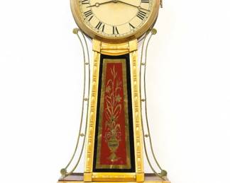 A 19th century American Banjo wall clock.  8-day Brass, weight driven time only movement with painted Iron dial and Roman numerals.  Gilded Mahogany case with pierced Brass arms, Brass dial door with flat glass over reverse painted throat and lower door glasses.  Some wear and minor touch-ups to gilding, re-painted dial, replaced finial, running when cataloged. 32 3/4" high overall. ESTIMATE $800-1,200