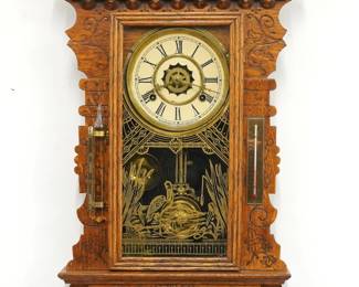 A turn of the century Gilbert Saranac model Kitchen wall clock.  8-day time, strike and alarm movement with papered metal dial and Roman numerals.  Oak case with pressed design features a shaped crest over a molded door with stenciled glass flanked by a barometer and thermometer above a shaped bracket drop.  Paper labels on back 50% intact.  Older refinishing with minor wear, re-papered dial, running when cataloged.  29" high.  ESTIMATE $100-150