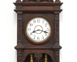 A late 19th century Waterbury Study No. 4 model wall clock.  8-day weight driven time and strike movement with two part porcelain dial and Arabic numerals.  Oak case with arched crest and turned finials over a circular dial door and open bracket drop.  Paper labels on back 80% intact.  Original dark alligatored finish with some wear, running when cataloged.  35 1/2" high plus weight drop.  ESTIMATE $200-400