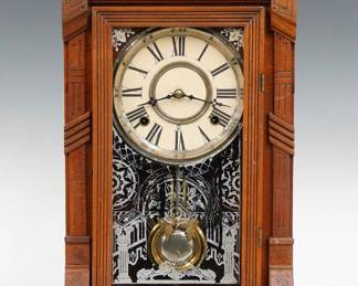 A late 19th century Gilbert Indra model shelf clock.  8-day time and strike movement with papered metal dial and Roman numerals.  Walnut case with shaped crest and turned finials above a single door with stenciled glass in a molded frame on a plinth base.  Paper label on back 90 % intact.  Refinished with minor wear, re-papered dial, running when cataloged.  20" high.  ESTIMATE $50-75