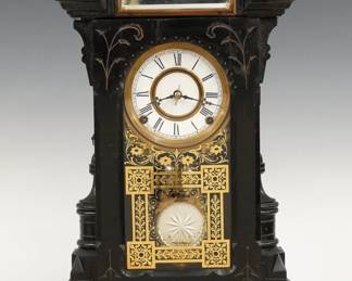 A 19th century Kroeber Lehigh model Victorian shelf clock.  8-day time and strike movement with two part porcelain dial and Roman numerals, fancy pendulum with mirrored insert.  Ebonized case with gallery top with inset beveled mirror above a single arched door with stenciled glass, flanked by turned pilasters on a molded base with key drawer.  Paper label on back 40% but very dark.  Original finish with some wear, dial flakes at winding holes, running when cataloged.  20 1/4" high.  ESTIMATE $200-300