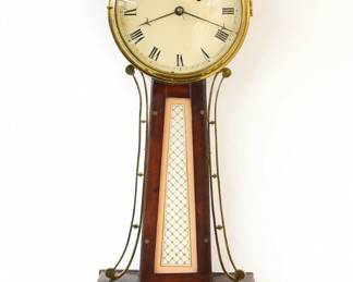 A 19th century American Banjo wall clock.  8-day Brass, weight driven time only movement with painted Iron dial and Roman numerals.  Gilded Mahogany case with pierced Brass arms, Brass dial door with convex glass over reverse painted throat and lower door glasses, face screws in throat frame.  Re-Gilded with minor wear, re-painted dial and glasses, replaced finial, running when cataloged. 33 1/2" high overall. ESTIMATE $1,000-1,500