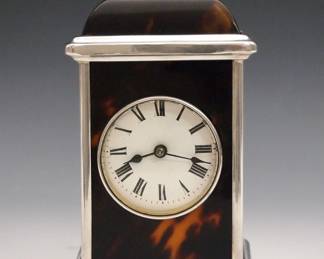 A turn of the century French calendar desk clock. 8-day time only movement with platform escapement and porcelain dial with Roman numerals, additional indicators for date and day of the week. Ebonized wooden case with Brass swing handle and applied details. Minor wear, running when cataloged. 7 1/4" high overall. ESTIMATE $200-300