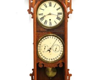 A late 19th century Welch Damrosch Model wall clock.  8-day time only movement with lower calendar mechanism indicating date with subsidiary day and month dials, papered metal dials with Roman/Arabic numerals.  Walnut case with carved detail features an shaped crest above two doors with circular dial glasses flanked by carved ears and panels on a molded base.  Paper label verso 80% intact.  Refinished with minor wear, re-papered dials, some staining on dial surround, running when cataloged.  41 1/4" high.  ESTIMATE $300-400