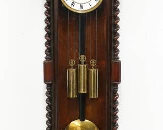 A 19th century three weight Vienna Regulator wall clock. 8-day time and strike movement with quarter hour Grand Sonnerie striking and a two-part porcelain dial with Roman numerals, within a molded Brass bezel. Rosewood case with features a shaped crown with turned finials over a rectangular door flanked by barley twist columns over a shaped lower drop with turned finials. Older finish with minor wear, dial hairlines, running when cataloged. 50" high overall. ESTIMATE $600-800