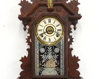 A turn of the century Ingraham Dauntless model Kitchen wall clock.  8-day time, strike and alarm movement with papered metal dial and Roman numerals.  Oak case with pressed design features a shaped crest over a molded door with stenciled glass with upper thermometer and lower level thermometer above a shaped bracket drop.  Paper labels on back 80% intact.  Older refinishing with minor wear, re-papered dial, running when cataloged.  25" high.  ESTIMATE $100-150