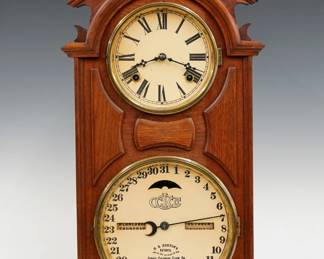 A late 19th century Ithaca Library Model shelf clock.  8-day time and strike movement with lower calendar mechanism and apertures indicating day and month, papered metal dials with Roman/Arabic numerals.  Walnut case with a pediment crest and turned finial above circular dial glasses with Brass bezels and molded panels on a molded base.  Refinished with slight wear, replaced crest and backboard, re-papered dials and rollers, running when cataloged.  24 3/4" high.  ESTIMATE $200-300