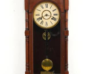 A turn of the century Ansonia Queen Elizabeth model wall clock.  8-day time and strike movement with papered metal dial and Roman numerals.  Mahogany case with a shaped crest and turned finials over an arched door flanked by turned columns over a shaped drop with turned rail.  Paper label on back 60% intact.  Older refinishing with minor wear, some dial wear, running when cataloged.  37" high.  ESTIMATE $300-400